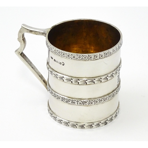 296 - A Victorian silver christening mug of tankard form with banded decoration and gilded interior.  hall... 