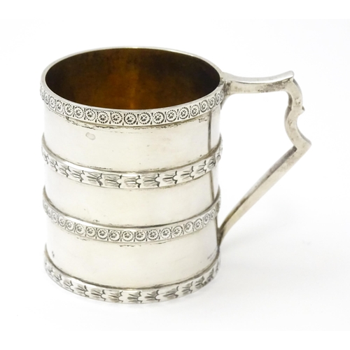 296 - A Victorian silver christening mug of tankard form with banded decoration and gilded interior.  hall... 