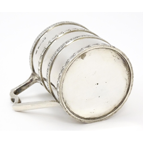 296 - A Victorian silver christening mug of tankard form with banded decoration and gilded interior.  hall... 