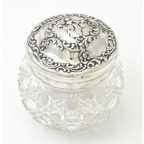 328 - A cut glass dressing table jar with embossed silver lid hallmarked London 1902, maker William Comyns... 