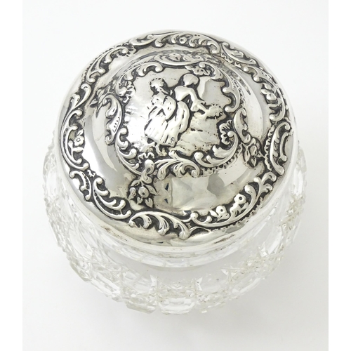 328 - A cut glass dressing table jar with embossed silver lid hallmarked London 1902, maker William Comyns... 