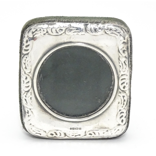 402 - An easel back photograph frame with silver surround having embossed decoration hallmarked Birmingham... 