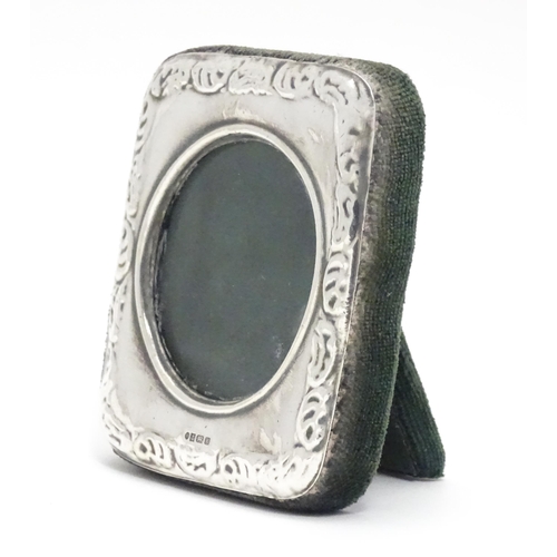 402 - An easel back photograph frame with silver surround having embossed decoration hallmarked Birmingham... 