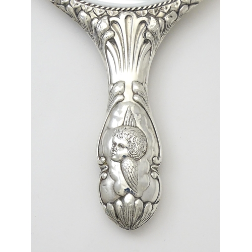 421 - A silver hand mirror with cherub decoration hallmarked Birmingham 1904, maker Mitchell Bosley & Co. ... 