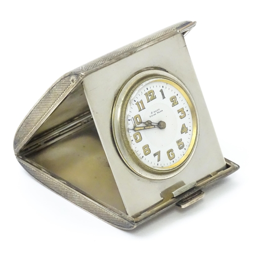 257 - A silver cased travelling clock, the case with engine turned decoration. Hallmarked Birmingham, 1925... 