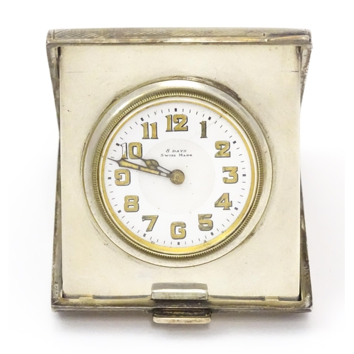 257 - A silver cased travelling clock, the case with engine turned decoration. Hallmarked Birmingham, 1925... 