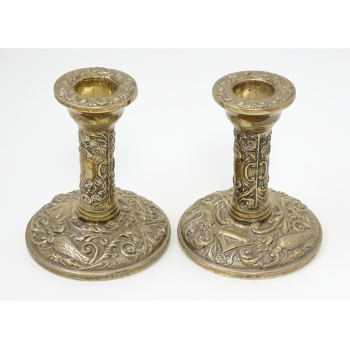 267 - A pair of silver candlesticks with floral scroll and bird decoration. Hallmarked Birmingham 1961, ma... 