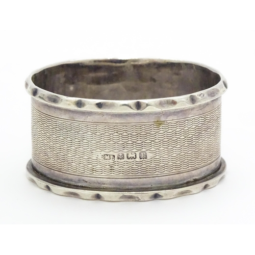 388 - A silver napkin ring hallmarked Birmingham 1929, maker Samuel Levi. Together with a glass caster wit... 