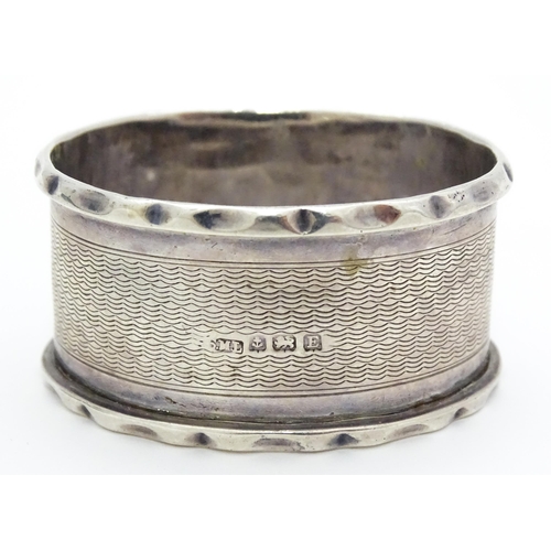 388 - A silver napkin ring hallmarked Birmingham 1929, maker Samuel Levi. Together with a glass caster wit... 