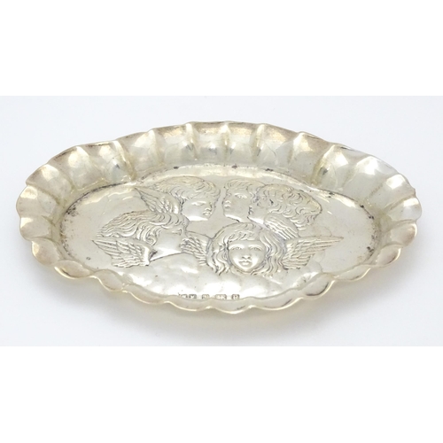 397 - A silver pin dish with embossed angel decoration hallmarked Birmingham 1904, maker Henry Matthews. A... 