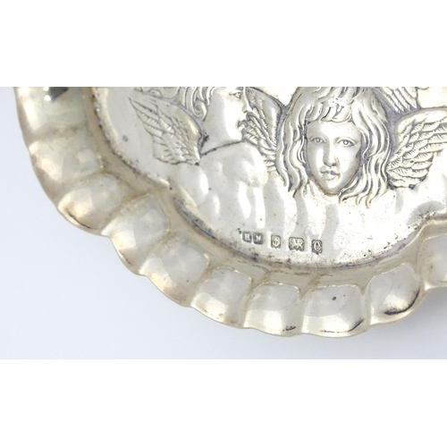 397 - A silver pin dish with embossed angel decoration hallmarked Birmingham 1904, maker Henry Matthews. A... 