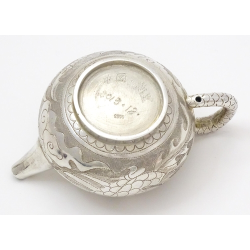 408 - A small Chinese export silver and white metal teapot with dragon and phoenix decoration. Marked unde... 