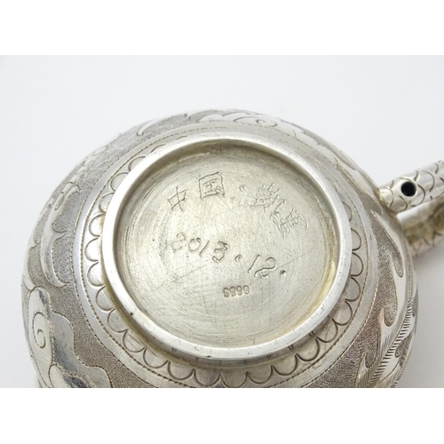 408 - A small Chinese export silver and white metal teapot with dragon and phoenix decoration. Marked unde... 