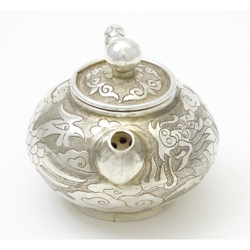 408 - A small Chinese export silver and white metal teapot with dragon and phoenix decoration. Marked unde... 