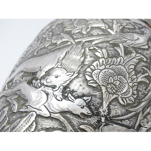 487 - A pair of Iranian / Persian silver vases decorated in relief with animals, birds and flowers. Possib... 