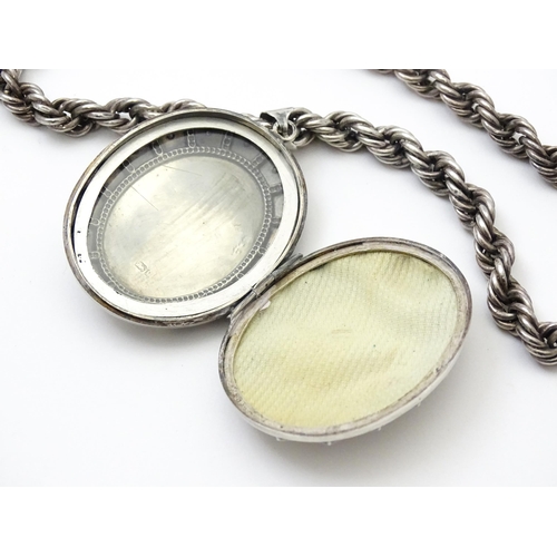 749 - Victorian silver oval locket with engraved floral decoration on white metal rope twist chain. Hallma... 