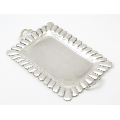 396 - A .925 Mexican silver miniature tray. Together with a white metal miniature / dolls house part tea s... 