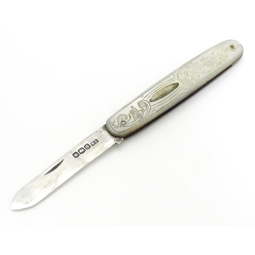 253 - A small silver folding fruit knife with mother of pearl handle having engraved decoration, hallmarke... 