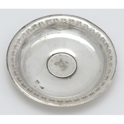 279 - A .800 silver / white metal pin dish of circular form with Ottoman coin style detail to centre. Appr... 