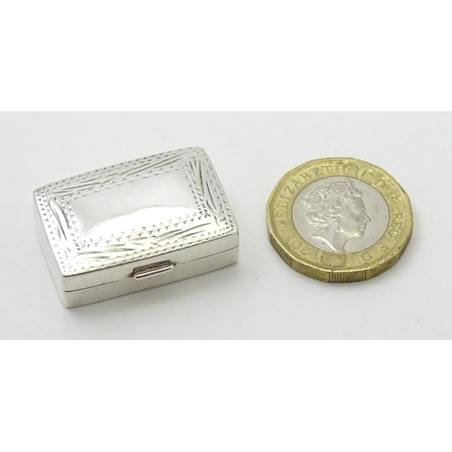 360 - A silver pill box with engraved decoration. Approx.  1 1/4