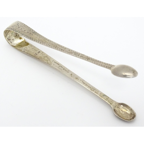 416 - Assorted silver items comprising George III silver sugar tongs with bright cut decoration, a silver ... 