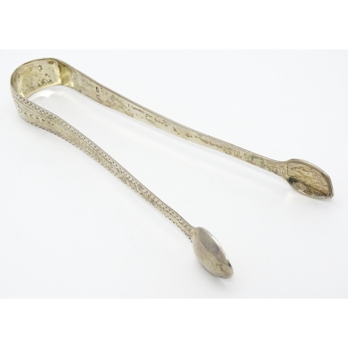 416 - Assorted silver items comprising George III silver sugar tongs with bright cut decoration, a silver ... 