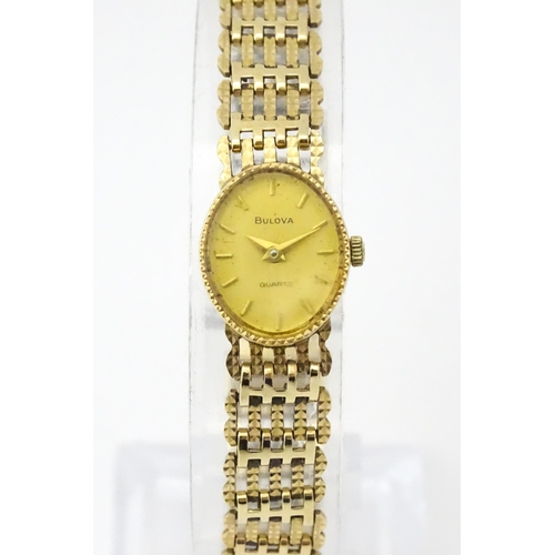 810 - A ladies 9ct gold cased Bulova wristwatch with 9ct gold strap. Approx 12