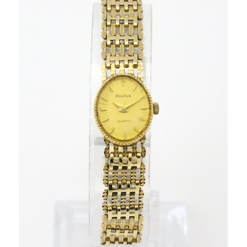 810 - A ladies 9ct gold cased Bulova wristwatch with 9ct gold strap. Approx 12