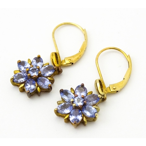586 - A pair of 9ct gold drop earrings set with tanzanite in a floral setting. Approx. 1 1/4
