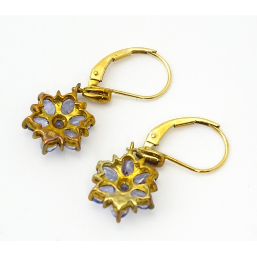 586 - A pair of 9ct gold drop earrings set with tanzanite in a floral setting. Approx. 1 1/4