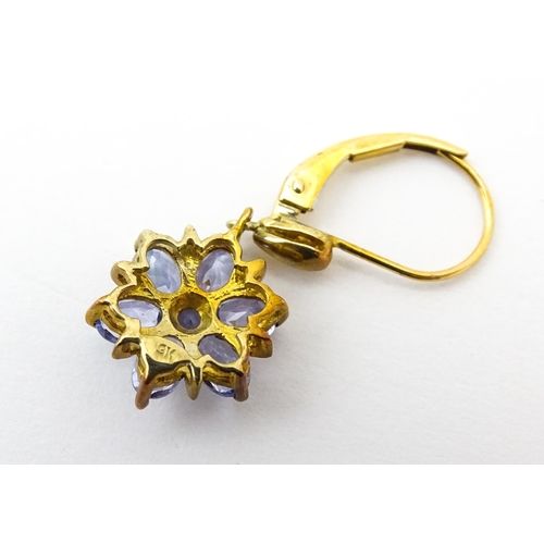 586 - A pair of 9ct gold drop earrings set with tanzanite in a floral setting. Approx. 1 1/4