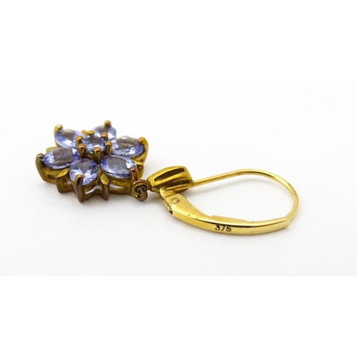586 - A pair of 9ct gold drop earrings set with tanzanite in a floral setting. Approx. 1 1/4