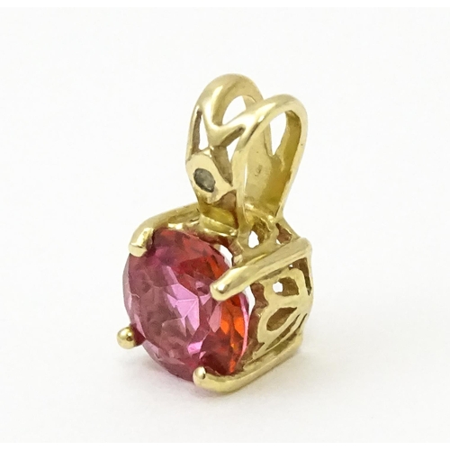 603 - A yellow metal pendant set with red and white stone. Approx. 1/2