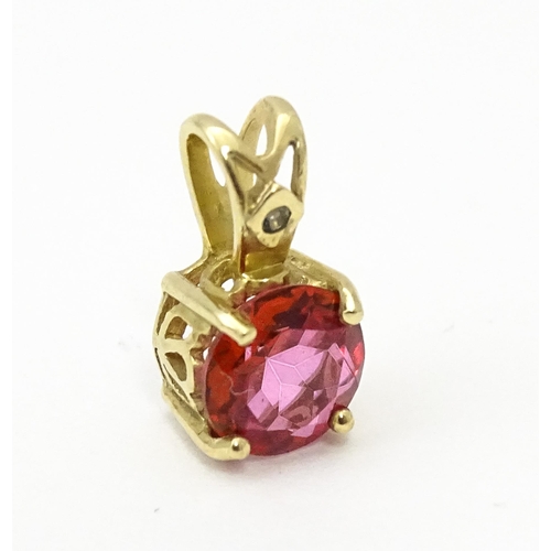 603 - A yellow metal pendant set with red and white stone. Approx. 1/2
