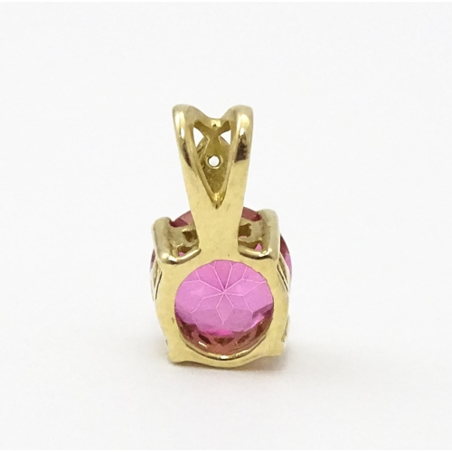 603 - A yellow metal pendant set with red and white stone. Approx. 1/2