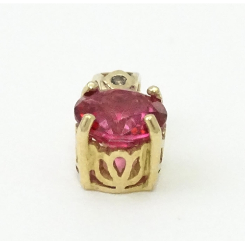 603 - A yellow metal pendant set with red and white stone. Approx. 1/2