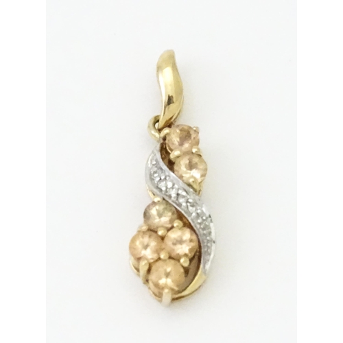 716 - A 9ct gold pendant set with diamonds and champagne coloured stones. Approx. 1