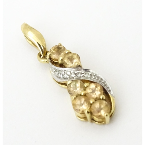 716 - A 9ct gold pendant set with diamonds and champagne coloured stones. Approx. 1