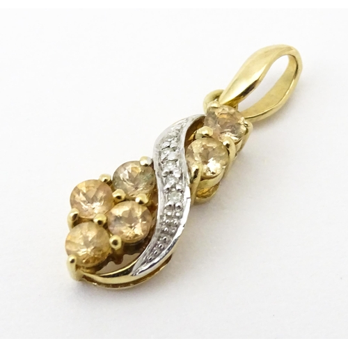 716 - A 9ct gold pendant set with diamonds and champagne coloured stones. Approx. 1