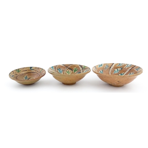 131 - Three graduated terracotta dishes decorated with stylised foliate detail. Largest approx. 12 3/4