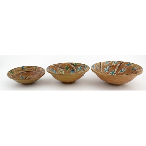 131 - Three graduated terracotta dishes decorated with stylised foliate detail. Largest approx. 12 3/4