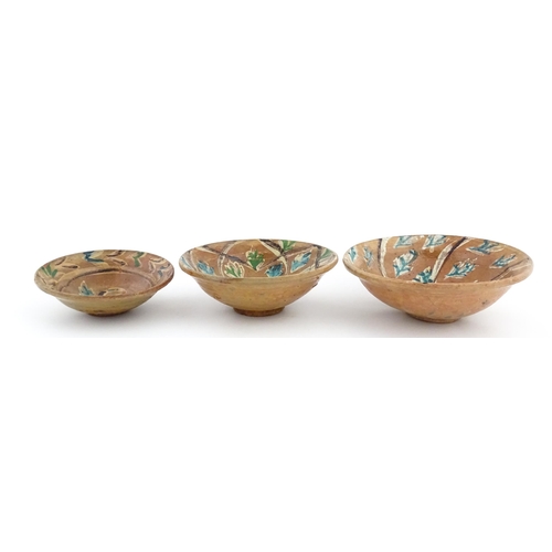 131 - Three graduated terracotta dishes decorated with stylised foliate detail. Largest approx. 12 3/4