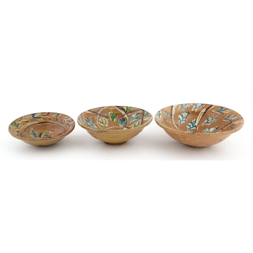 131 - Three graduated terracotta dishes decorated with stylised foliate detail. Largest approx. 12 3/4