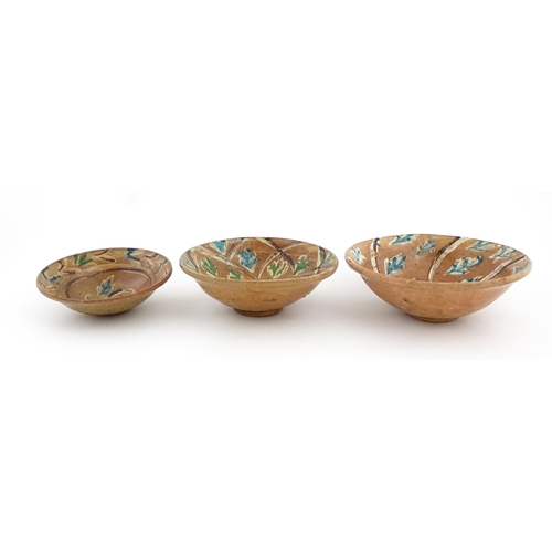 131 - Three graduated terracotta dishes decorated with stylised foliate detail. Largest approx. 12 3/4