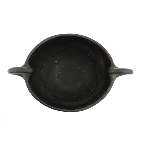 132 - A studio pottery terracotta bowl with black glaze and twin loop handles. Approx. 15