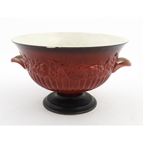 139 - A Carlton Ware pedestal bowl with twin handled and relief foliate detail. Marked under Rouge Royale.... 