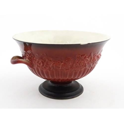 139 - A Carlton Ware pedestal bowl with twin handled and relief foliate detail. Marked under Rouge Royale.... 