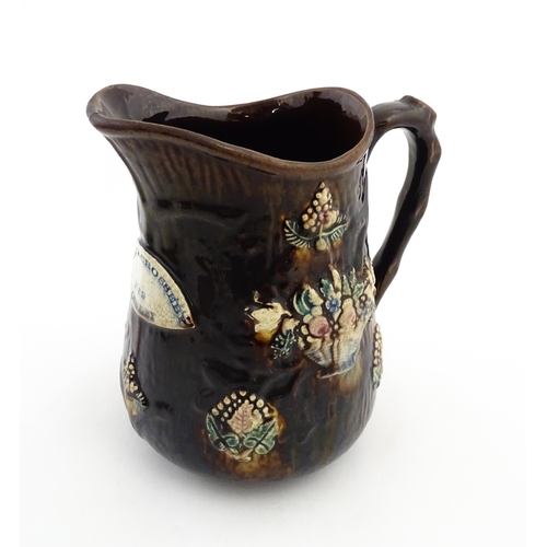 144 - A large 19thC Measham bargeware jug bearing a plaque for Mary A. Crosseby 1882 Mossleym decorated wi... 