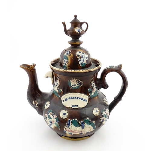 146 - A large 19thC Measham bargeware teapot bearing a plaque for P. R. Greatorex 1891, decorated with fru... 