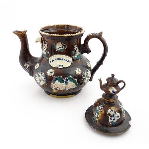 146 - A large 19thC Measham bargeware teapot bearing a plaque for P. R. Greatorex 1891, decorated with fru... 